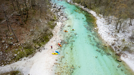 Drone shot of whitewater kayaker dealing with crystal clear rapids of Soca river in Slovenia 