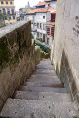 Estrechas escaleras de una de las calles de Oporto con los edificios de la ciudad de fondo.