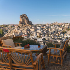 view from a street cafe with wooden chairs and tables on an ancient earthen city in Cappadocia, Turkey - 593714618