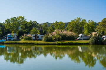 Motorhomes and bicycles on the lake by the river with camping tables, sport fishing and cycling for relaxation, summer travel and outdoor recreation, authentic sustainability, natural beauty of nature