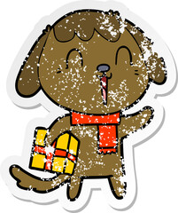 distressed sticker of a cute cartoon dog with christmas present