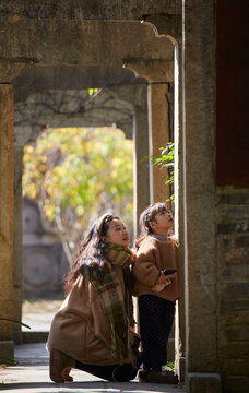 Asian mother and daughter observe and play in ancient city buildings