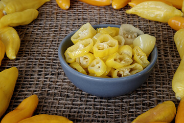 Chili pickle in a bowl. Yellow pickled chili pepper vegetable slices.