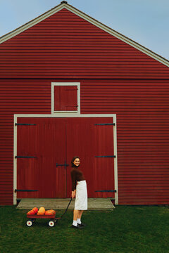 Smiling Woman pulling a pumpkin cart 