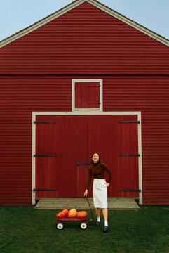 Smiling Woman pulling a pumpkin cart 