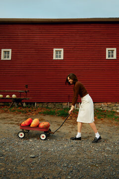 Trendy Woman pulling a pumpkin cart