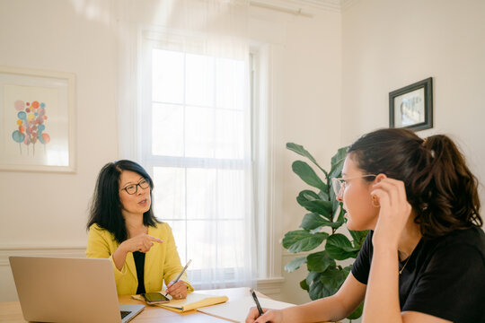 woman interviewing a young woman, who is listening carefully 