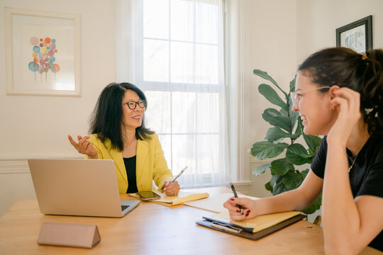 woman interviewing a young woman, who is listening carefully 