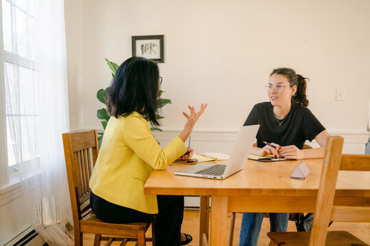 mature woman interviewing a young woman, who is listening carefully 