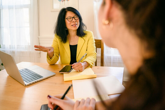 woman interviewing a young woman, who is listening carefully 
