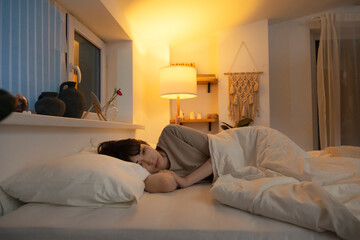 Asian woman lying in bed having insomnia