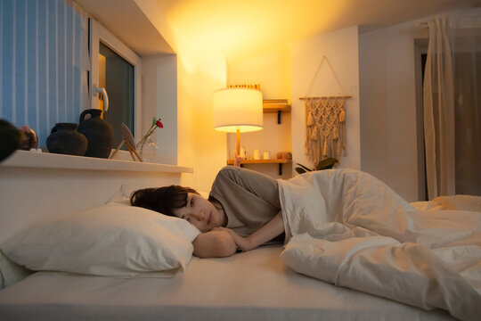Asian woman lying in bed having insomnia