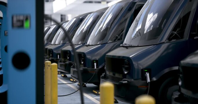 CU shot of fleet modern electric EV delivery vans are being charged in company parking garage