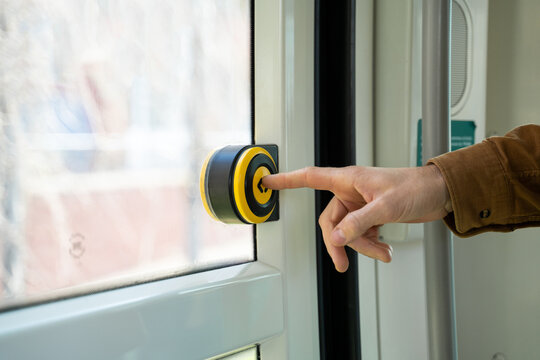 Man taking train pressing stop button