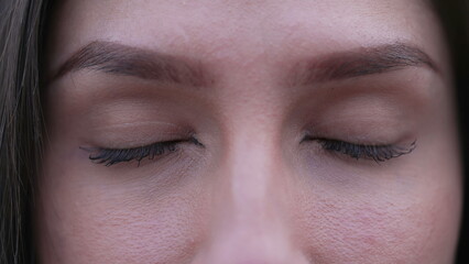 Woman closing eyes in meditation. Pensive female person macro detail closeup with eye closed in contemplation