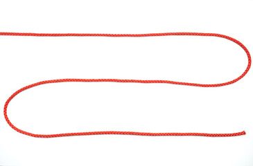 Red rope twisted in the form of a zigzag on a white isolated background. Red nylon rope lies on a...