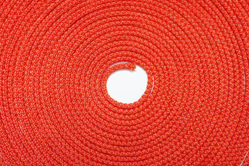Fototapeta na wymiar Background of red rope twisted in a circle. Texture of red nylon rope close up. Free space for text and advertising. Roll of red rope as a beautiful background