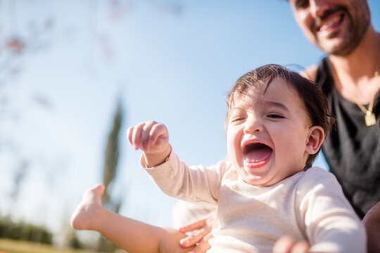 Laughing baby getting tickled by smiling father