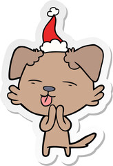 sticker cartoon of a dog sticking out tongue wearing santa hat