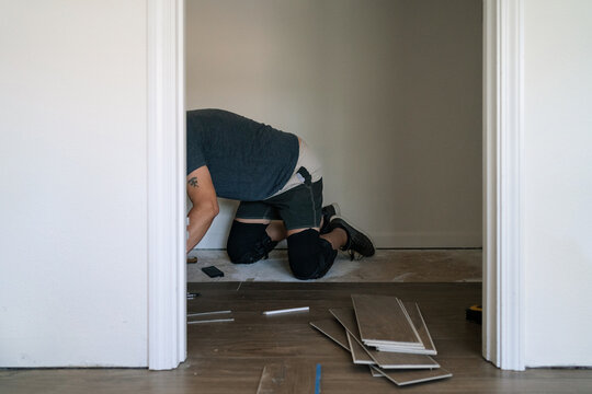 Unrecognizable man installing a wood floor