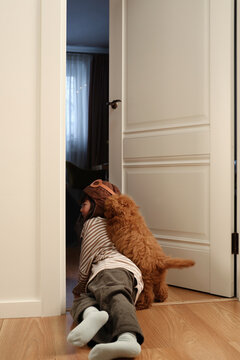 Little girl and puppy have fun at home