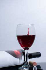 A bottle of wine and drops dripping in a glass