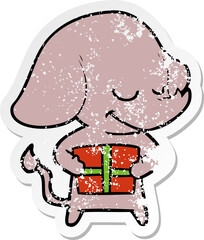 distressed sticker of a cartoon smiling elephant with present