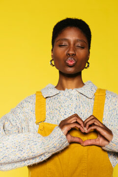 Cheerful woman posing in yellow wall