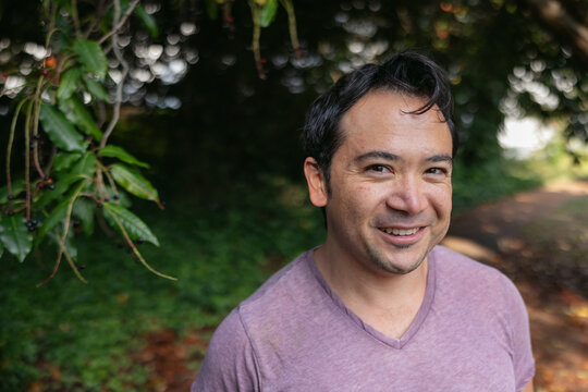Smiling man outside in nature park.