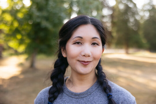 Happy, natural woman portrait in park.