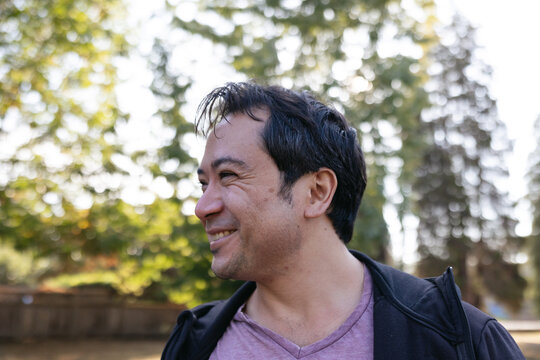 Smiling man outside in nature park.