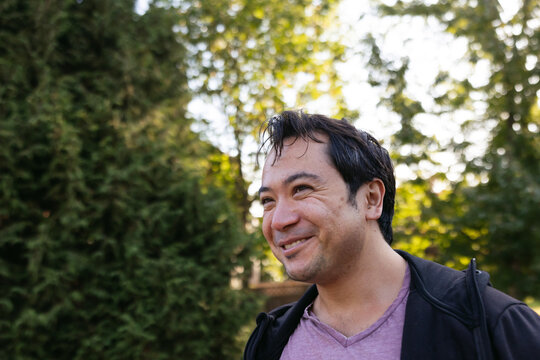 Smiling man outside in nature park.