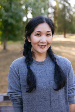 Happy, natural woman portrait in park.