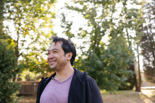 Smiling man outside in nature park.