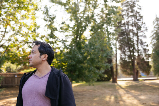 Smiling man outside in nature park.