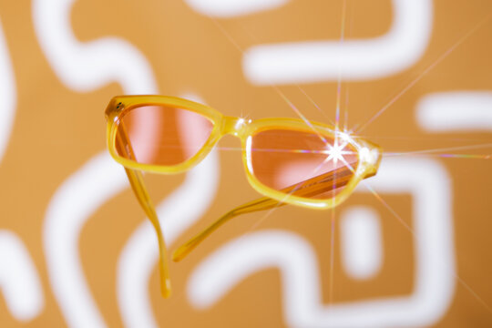 Orange sunglasses front, with pink lenses floating 