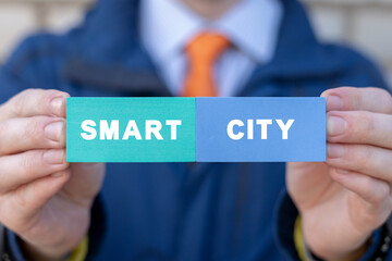 Man holding colorful styrofoam blocks with inscription: SMART CITY. Concept of smart city with smart services, internet of things (IOT), AI, networks, big data, augmented reality.