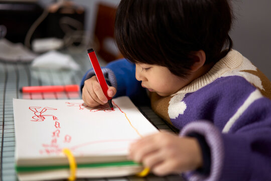 Asian little boy drawing at home