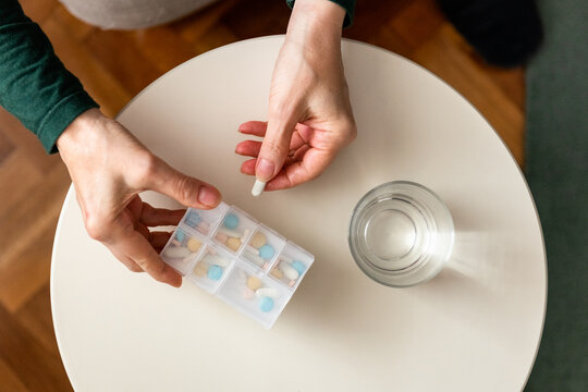 Taking pills / drugs from pill box / organizer at home