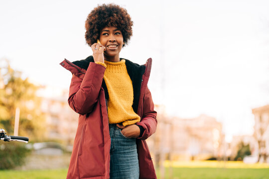 Smiling Black Woman Talking On Smartphone On Street