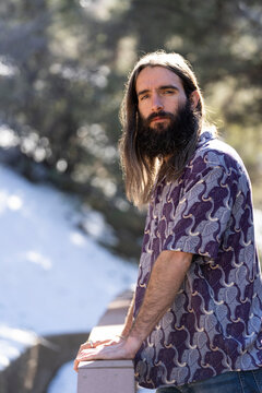 Male with long hair and beard on porch