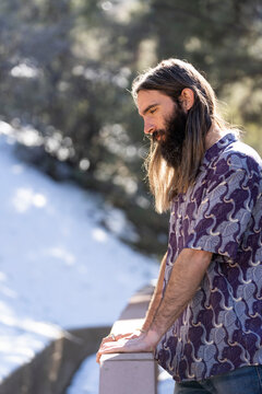 Male with long hair and beard on porch