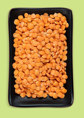 Red lentil in bowl isolated on pink background. Top view