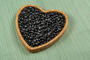 heart shaped black bean bowl on green tablecloth