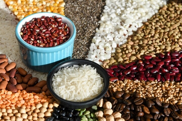 Bowl with raw white rices and beans on various seeds grain