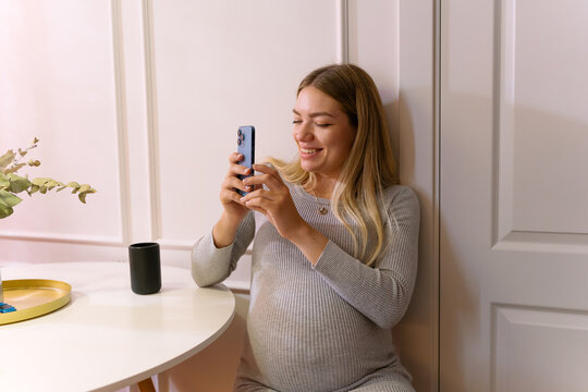 Smiling Pregnant Woman Taking A Picture In A Sunny Room