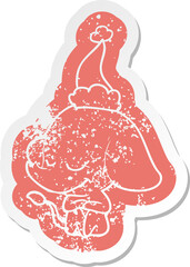 cartoon distressed sticker of a smiling elephant wearing santa hat