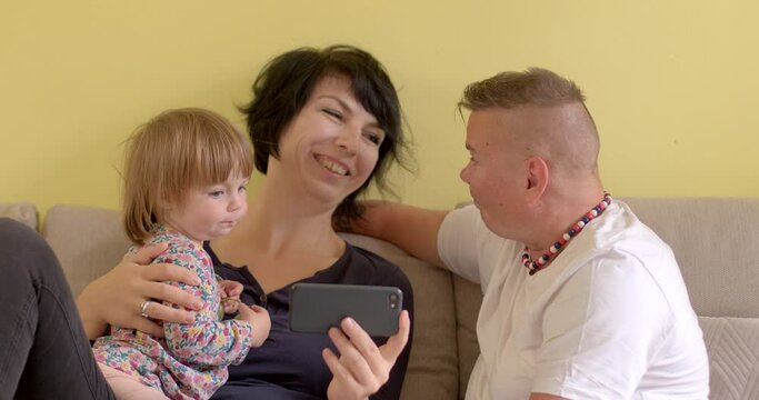 Portrait of adult women with a small child baby girl. LGBT parenting and leisure. Lesbian people raising children as foster care parents. Spending free time.