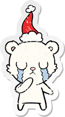 crying polar bear distressed sticker cartoon of a wearing santa hat