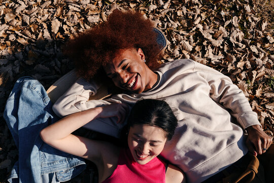 Happy multiracial friends lying outdoors